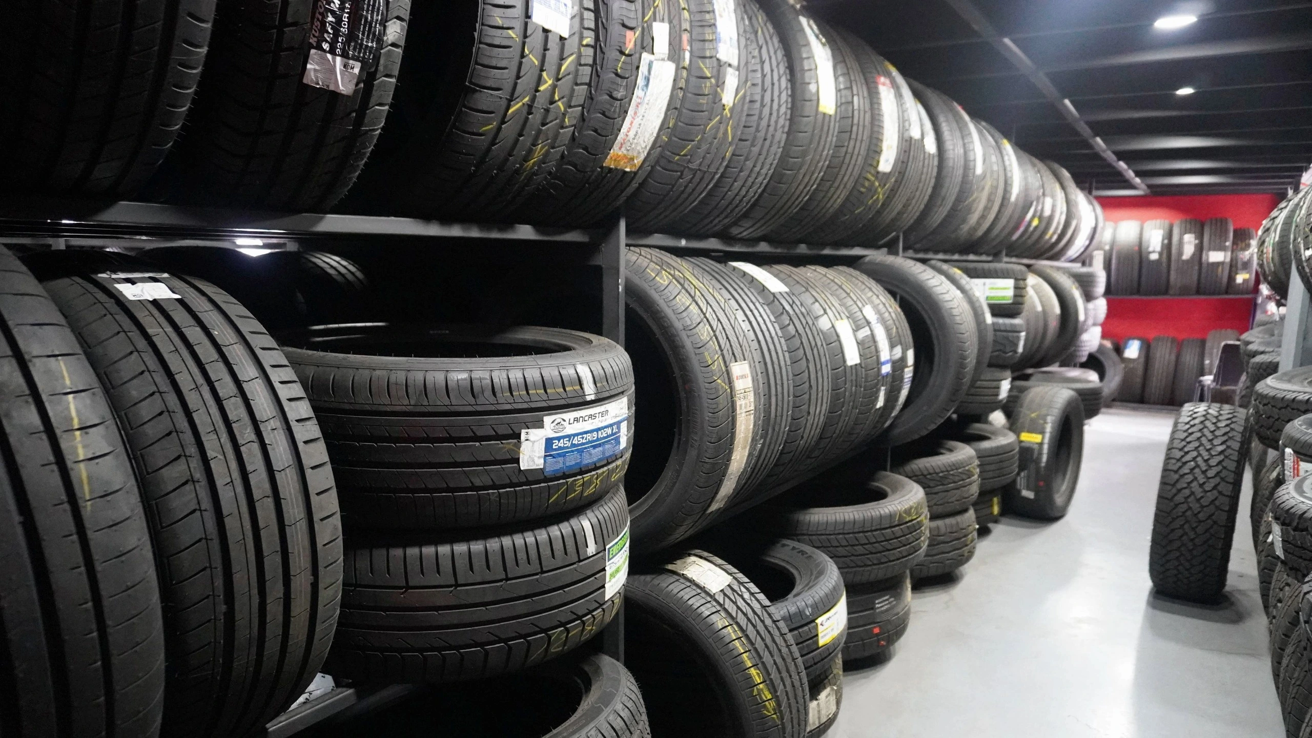 Estanterías con llantas nuevas organizadas en un almacén.